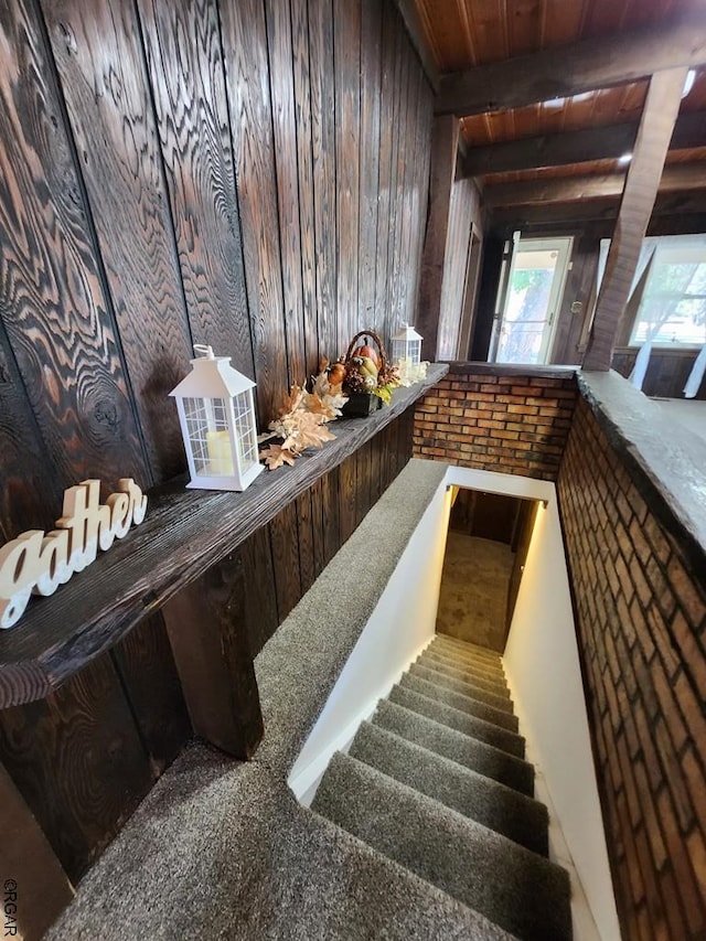 interior space featuring wood ceiling, beam ceiling, dark brown cabinets, and wood walls