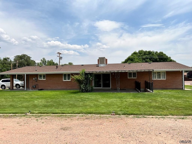 rear view of house with a yard and a carport