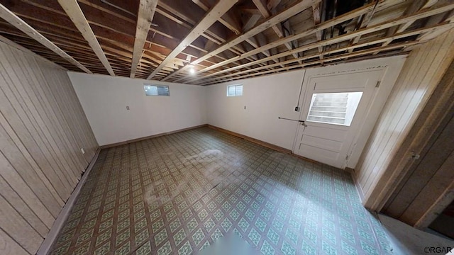 basement featuring wood walls