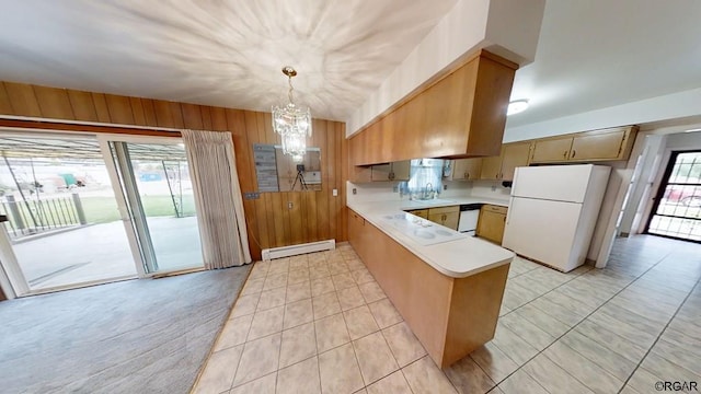 kitchen with wooden walls, sink, white refrigerator, a baseboard heating unit, and kitchen peninsula