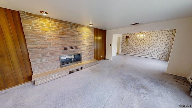 unfurnished living room featuring a baseboard radiator, a stone fireplace, and light carpet