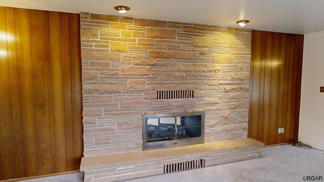 room details with a stone fireplace and carpet flooring