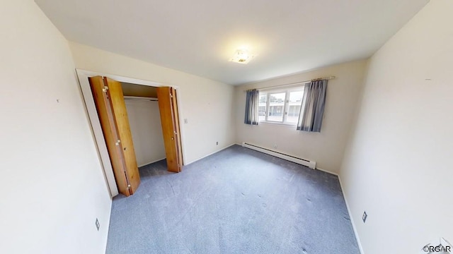 unfurnished bedroom featuring carpet floors, a closet, and a baseboard heating unit