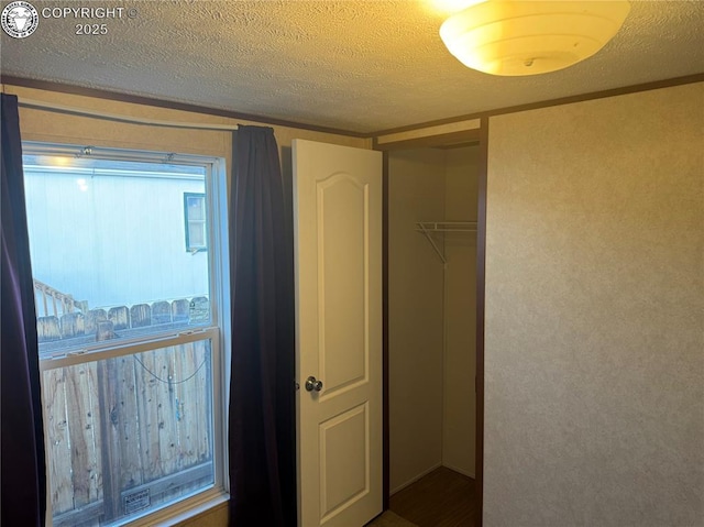 unfurnished bedroom with a textured ceiling and a closet