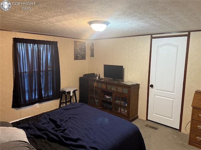 bedroom featuring light carpet and a textured ceiling