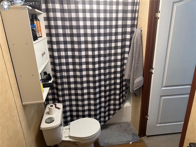 bathroom featuring shower / bath combination with curtain and toilet