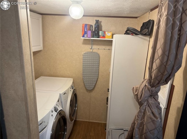 washroom featuring dark hardwood / wood-style flooring, cabinets, washer and dryer, and a textured ceiling