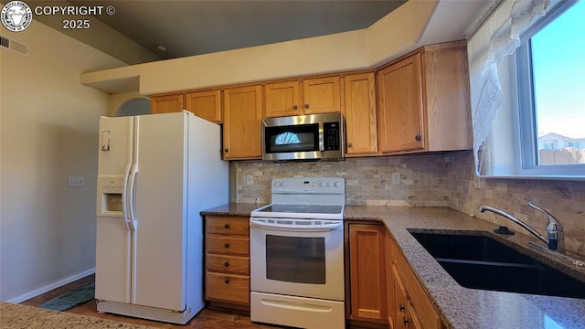 1002 Cedarcrest Dr, Pueblo, CO 81005 - kitchen featuring white appliances, backsplash, stone countertops, and brown cabinets