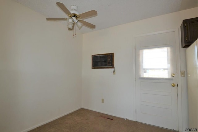 carpeted spare room featuring an AC wall unit and ceiling fan