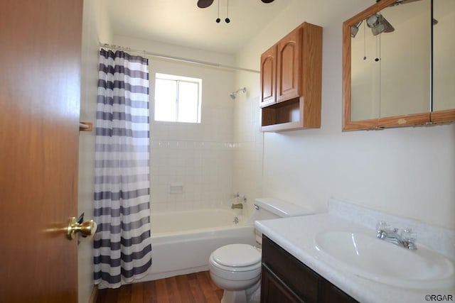 full bathroom featuring toilet, wood-type flooring, shower / tub combo, vanity, and ceiling fan