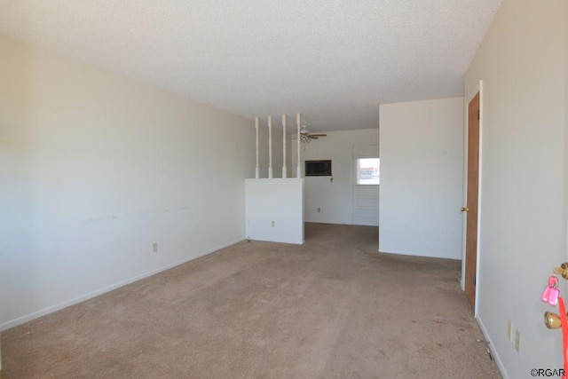 spare room with light colored carpet and a textured ceiling