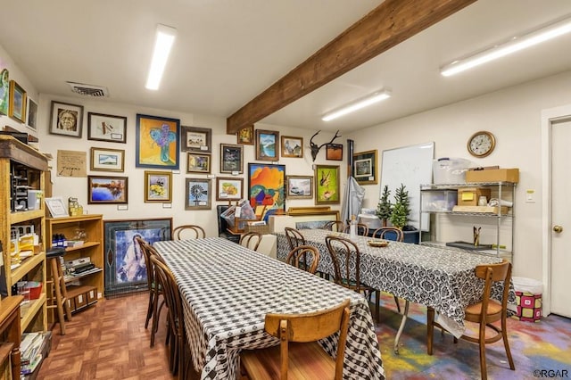 dining area featuring parquet floors and beamed ceiling