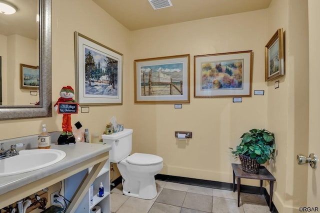 bathroom with toilet, sink, and tile patterned flooring