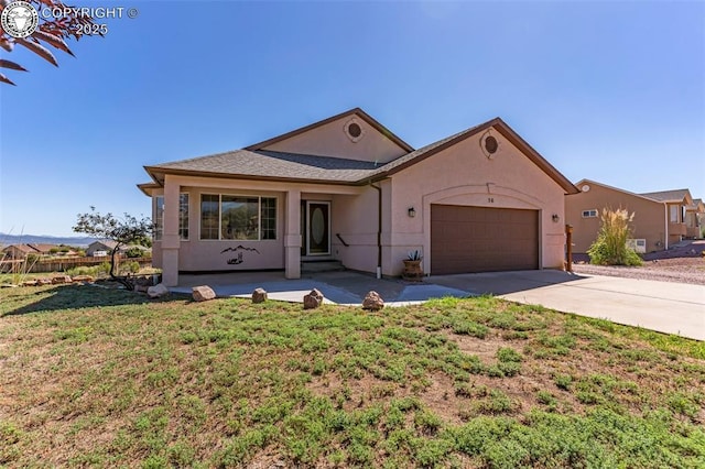 view of front of house featuring fence, stucco siding, a front lawn, concrete driveway, and a garage