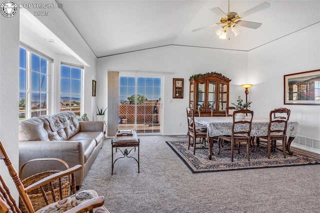 living area with carpet floors, plenty of natural light, ceiling fan, and vaulted ceiling