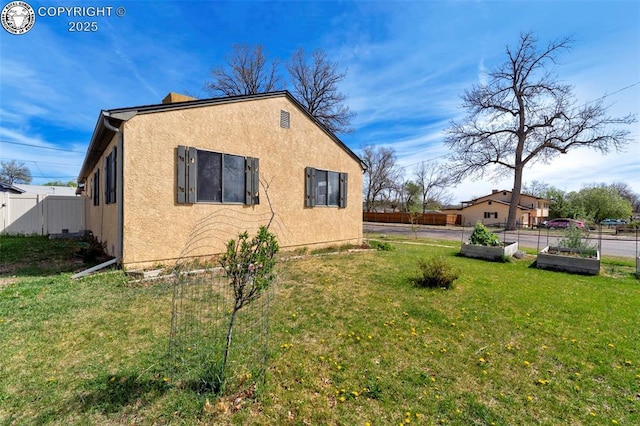 1815 N 10th St, Canon City, CO 81212 - view of home's exterior featuring a yard, stucco siding, fence, and a vegetable garden