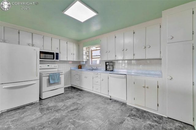 1815 N 10th St, Canon City, CO 81212 - kitchen with white cabinets, a sink, light countertops, white appliances, and backsplash
