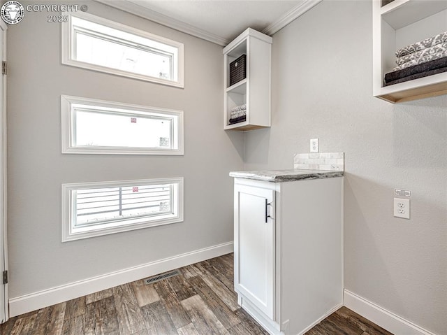 clothes washing area with crown molding and dark hardwood / wood-style flooring