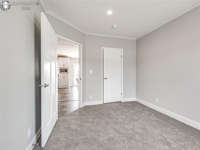 unfurnished room with crown molding and carpet flooring