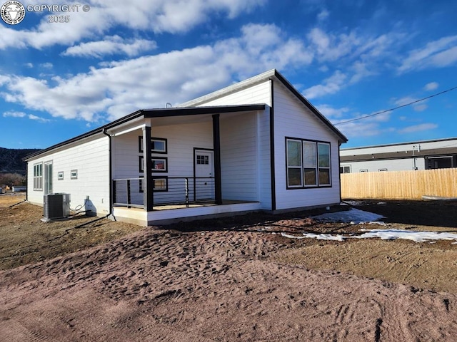 rear view of property featuring central AC unit and covered porch