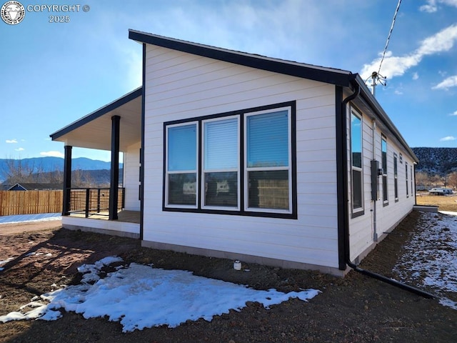 view of snow covered exterior with a mountain view and a porch