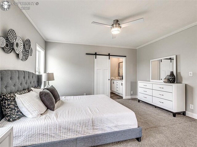 carpeted bedroom with crown molding, ceiling fan, a barn door, and ensuite bath