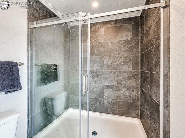 bathroom with enclosed tub / shower combo, ornamental molding, and toilet