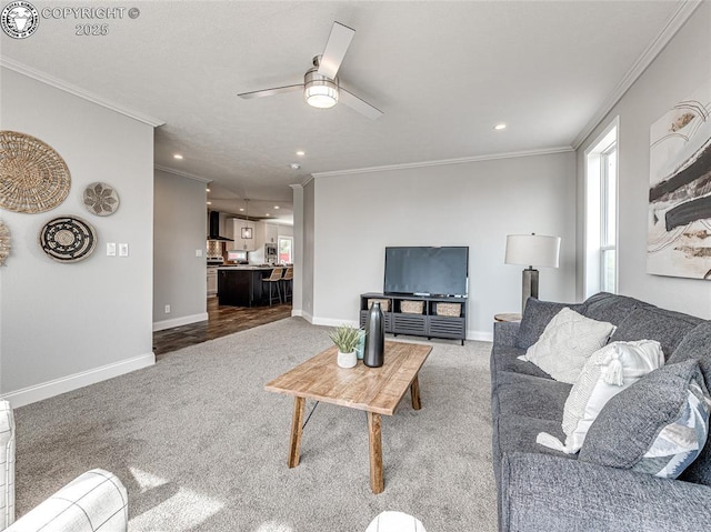 carpeted living room featuring ornamental molding and ceiling fan