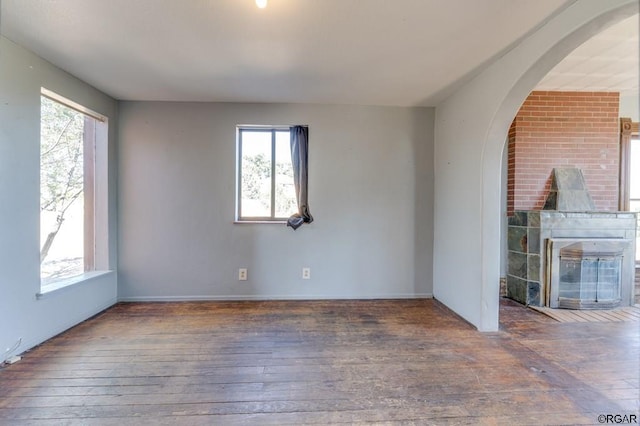 empty room featuring a healthy amount of sunlight and dark hardwood / wood-style floors