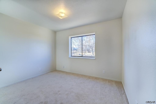 spare room featuring light colored carpet