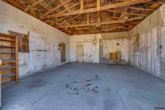 misc room with lofted ceiling and concrete floors