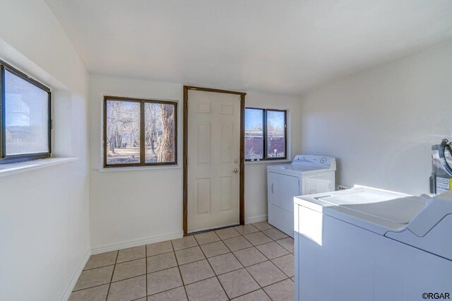 clothes washing area with light tile patterned floors and independent washer and dryer