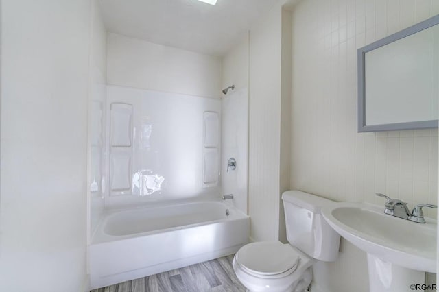 full bathroom with hardwood / wood-style flooring, bathing tub / shower combination, sink, and toilet