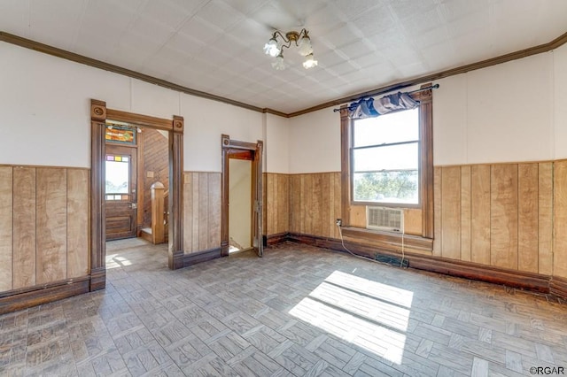 empty room featuring crown molding, parquet flooring, and a chandelier