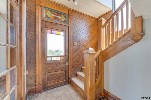 foyer entrance with light parquet floors and wood walls