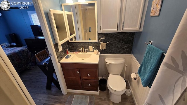 bathroom with hardwood / wood-style flooring, vanity, toilet, and tasteful backsplash