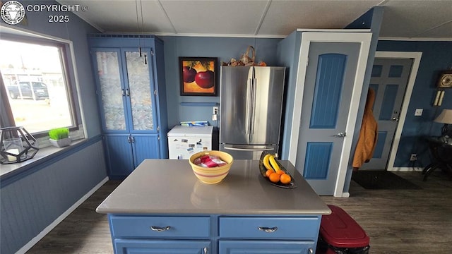 kitchen featuring blue cabinets, crown molding, stainless steel refrigerator, dark hardwood / wood-style floors, and a kitchen island