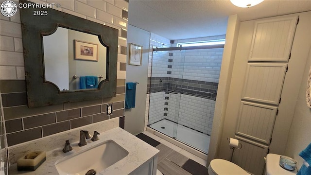 bathroom featuring tasteful backsplash, vanity, toilet, and an enclosed shower