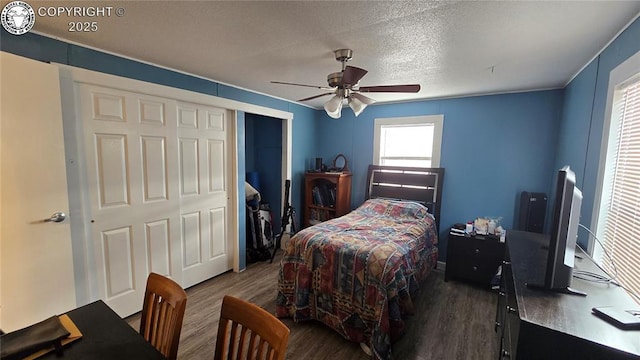 bedroom with ceiling fan, dark hardwood / wood-style floors, a closet, and a textured ceiling