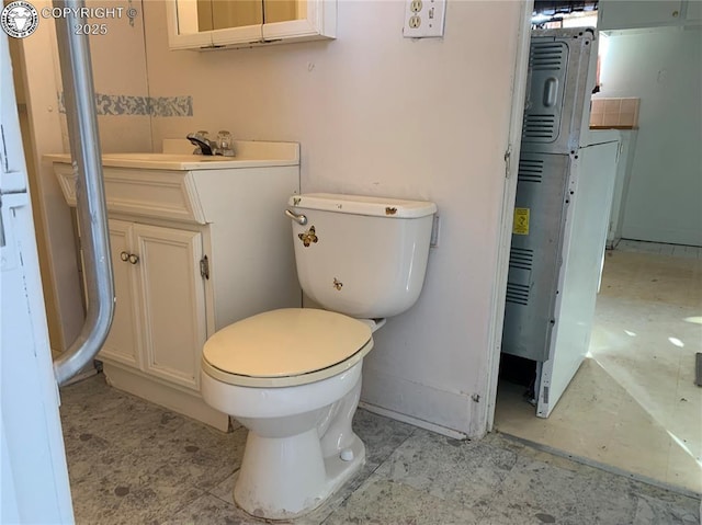 bathroom with toilet, washer / dryer, and vanity