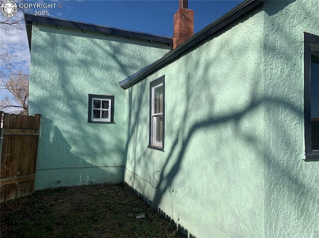 view of property exterior featuring fence and stucco siding