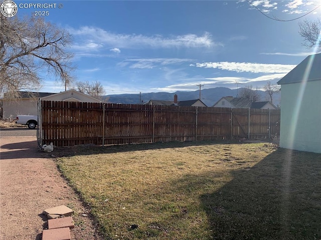 view of yard featuring fence and a mountain view