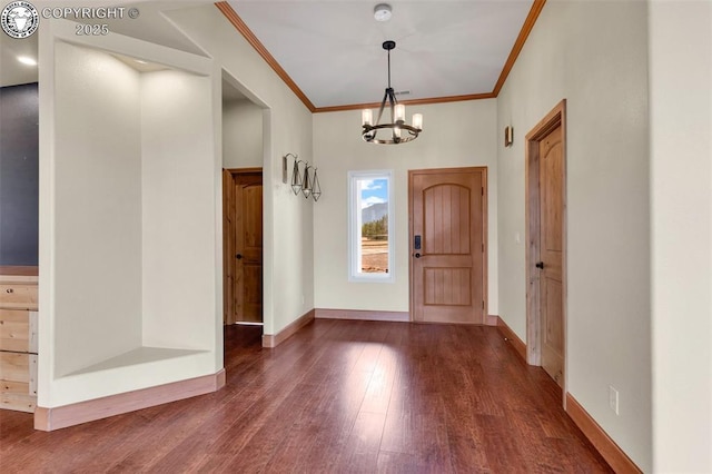 foyer with dark hardwood / wood-style flooring, crown molding, and a chandelier