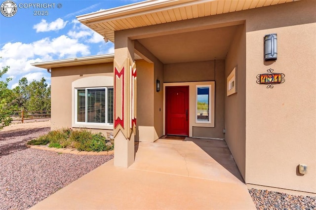 view of exterior entry with a patio