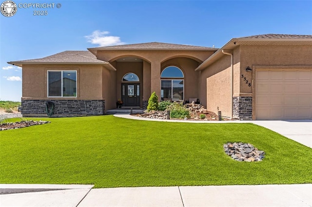 3528 Telegraph Trl, Canon City, CO 81212 - view of front of home featuring stone siding, a garage, a front yard, and stucco siding