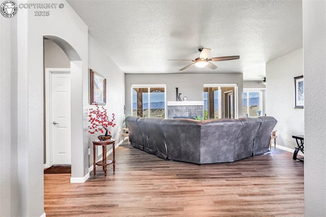 3528 Telegraph Trl, Canon City, CO 81212 - living room with wood finished floors, a ceiling fan, arched walkways, plenty of natural light, and a textured ceiling