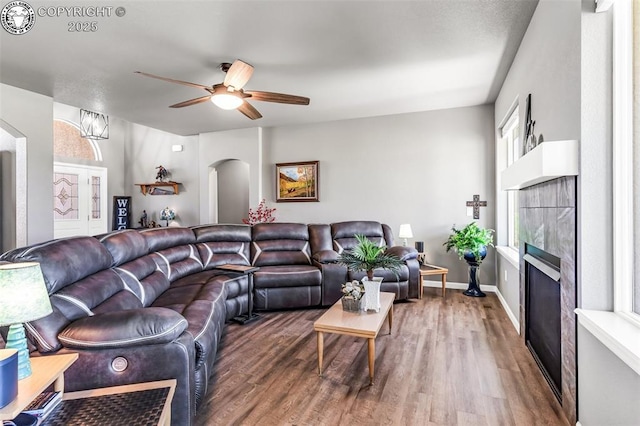 3528 Telegraph Trl, Canon City, CO 81212 - living room with arched walkways, a tile fireplace, wood finished floors, and ceiling fan