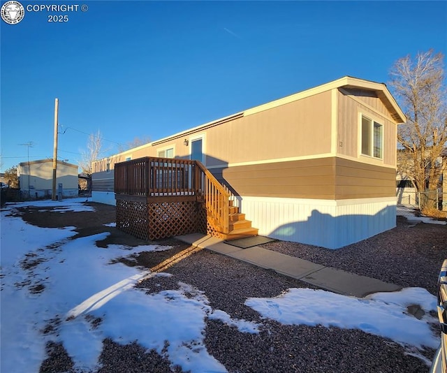 view of snow covered exterior with a deck