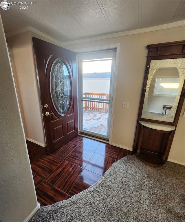 entryway featuring crown molding and a textured ceiling