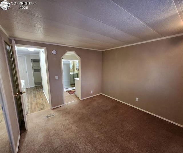 empty room with crown molding, a textured ceiling, and carpet flooring